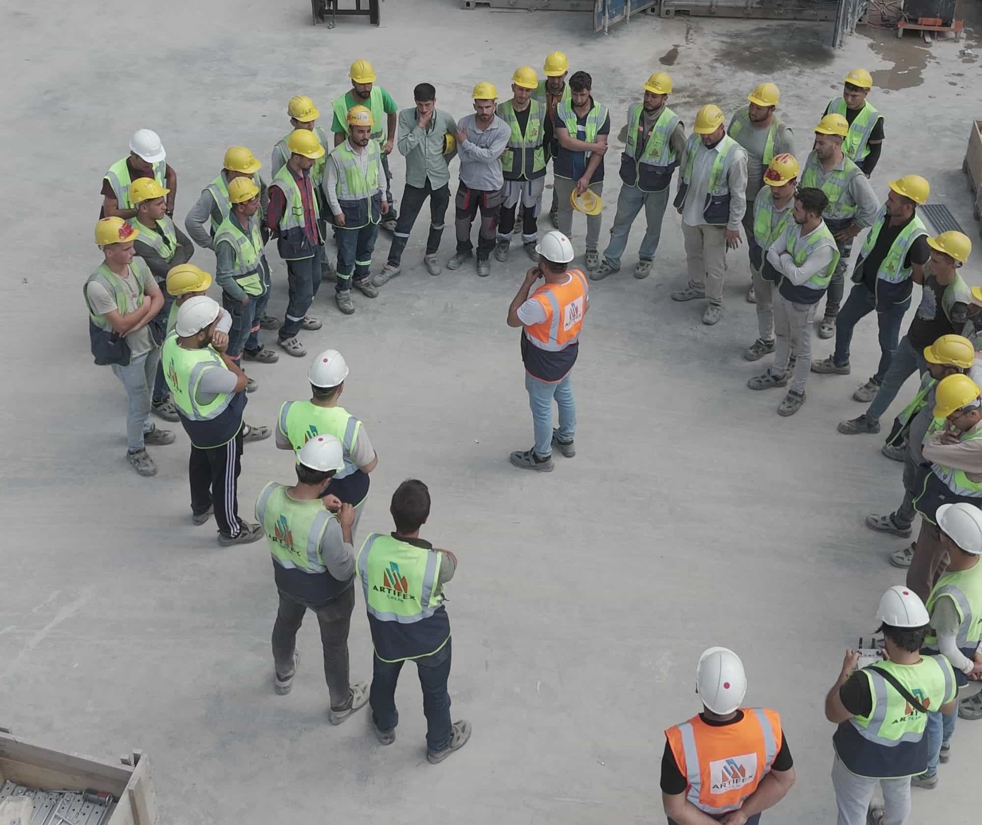 Site team wearing Artifex Çelik vests in a meeting on site
