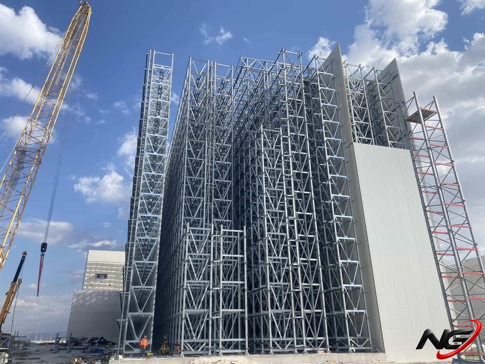 Racking blocks and façade panels rising with a tower crane at the Abalıoğlu milk powder plant in Niğde