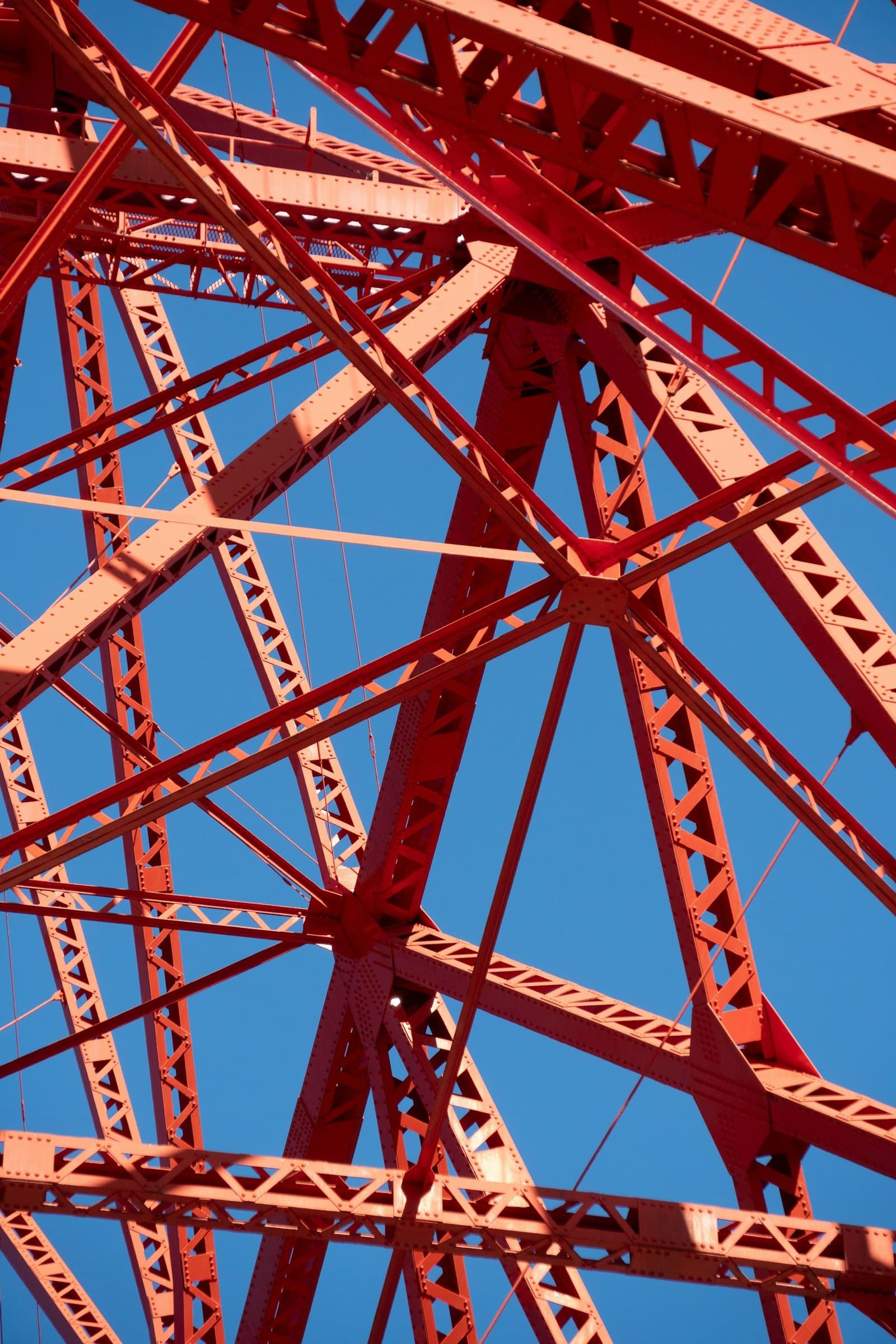 Orangefarbenes Stahlfachwerk vor blauem Himmel, Ansicht von unten