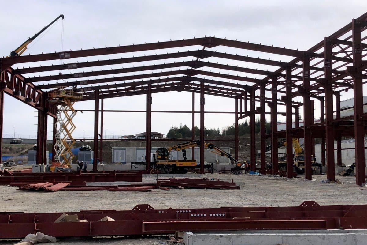 Steel frame with roof trusses being installed from an aerial platform