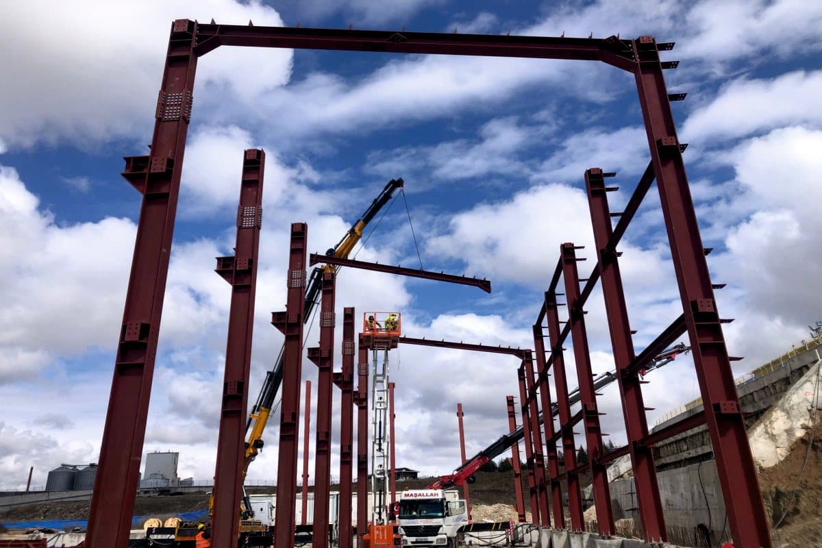 Steel columns and crane under a cloudy sky