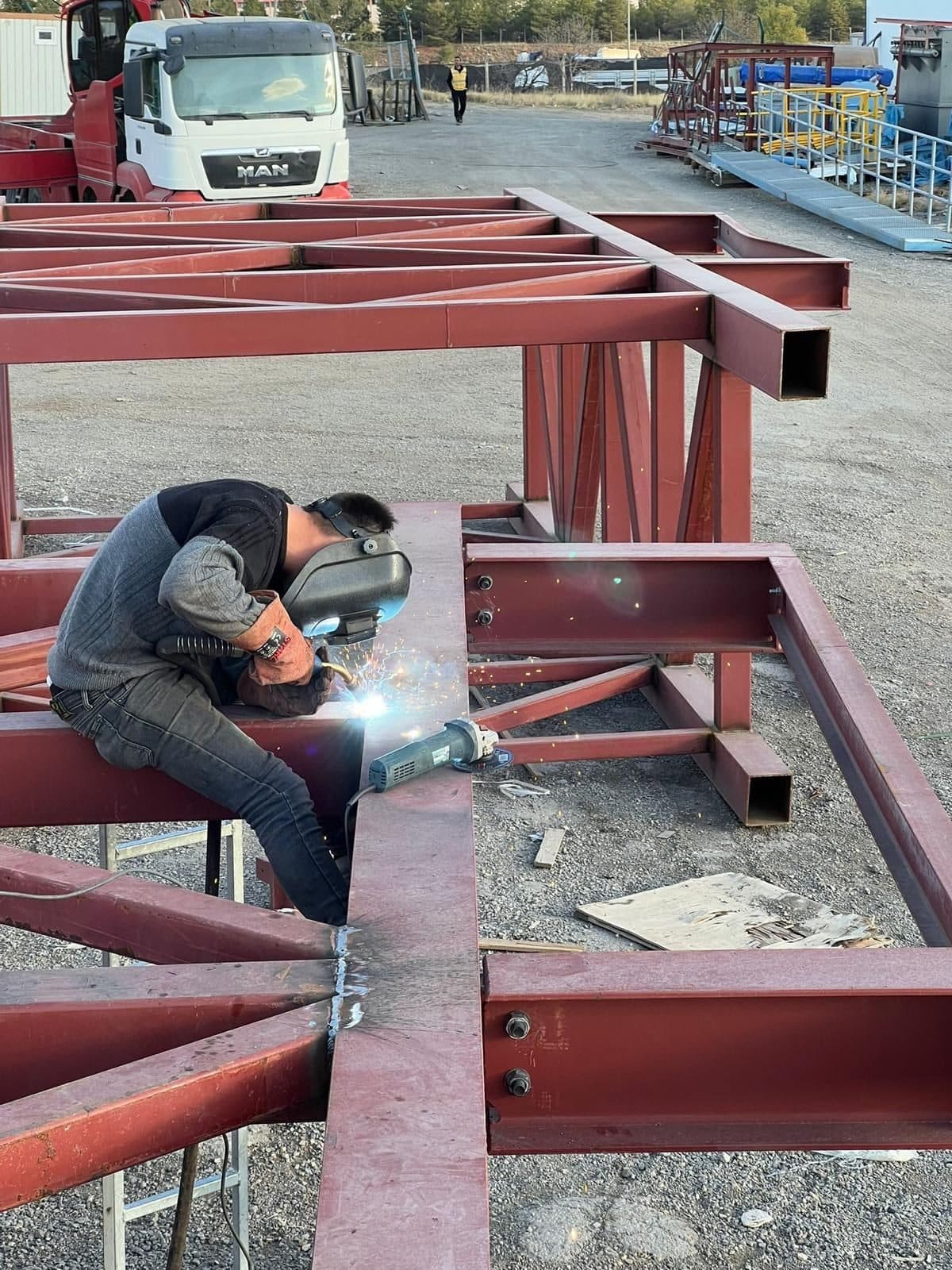 Welder working on a steel lattice member on site