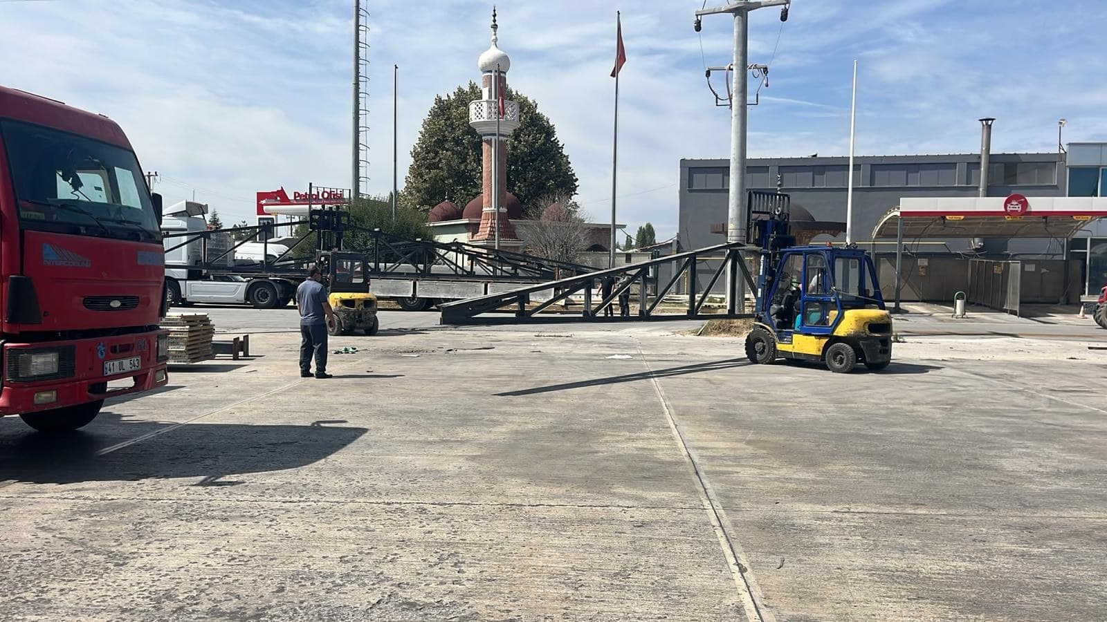 Steel lattice truss lowered on site and a forklift