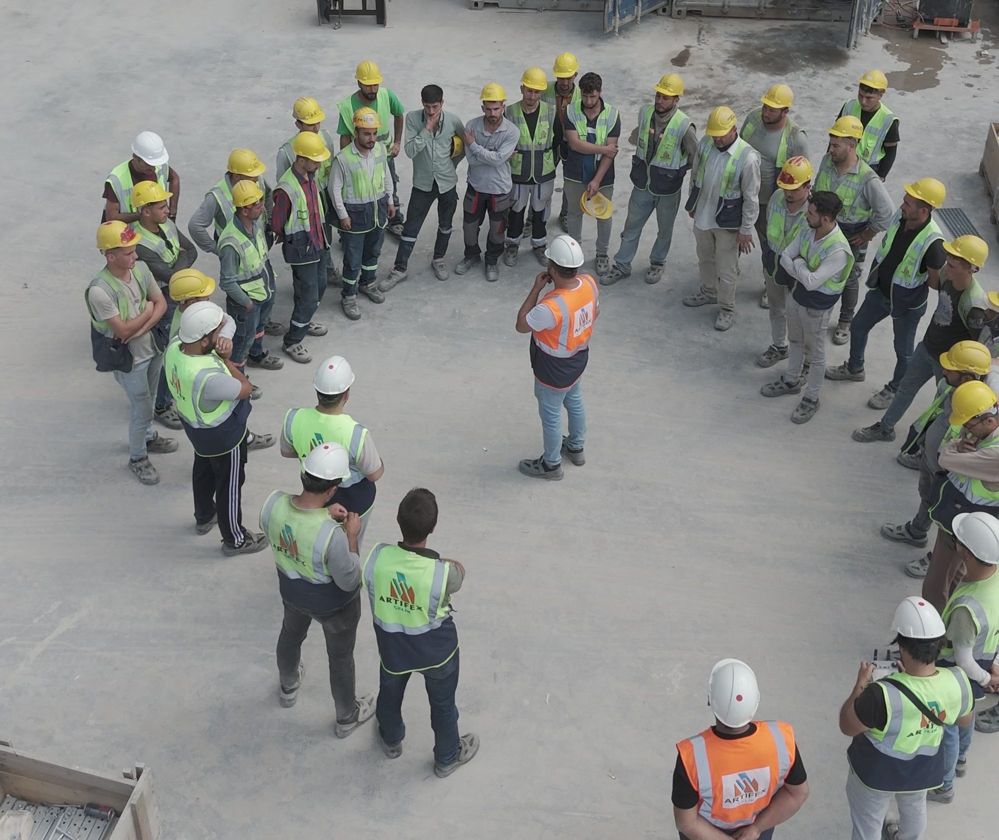 Site team wearing Artifex Çelik vests in a meeting on site